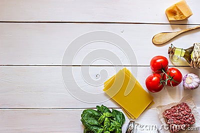 Lasagna, tomatoes, minced meat and other ingredients. White wooden background. Italian cuisine Stock Photo