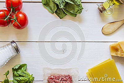 Lasagna, tomatoes, minced meat and other ingredients. White wooden background. Italian cuisine Stock Photo
