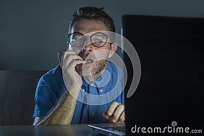 Lascivious aroused addict man in nerd glasses watching sex movie online late night at laptop computer looking pervert and Stock Photo