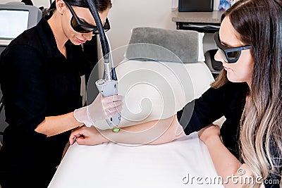Laser hair removal session with beauty technician and female patient, epilating arm hair, in a cosmetology skin clinic Stock Photo