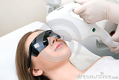 Laser hair removal of the mustache and chin of a young beautiful woman. Depilation on the face. Device for laser Stock Photo