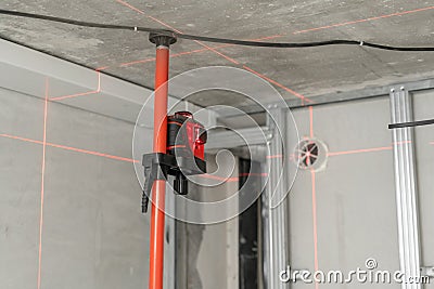 Laser measurement during renovation. Construction tools and equipment. Red laser light lines for level measure. Stock Photo