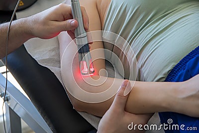 Laser therapy in hand used to treat pain. Stock Photo