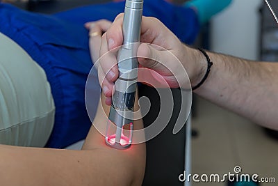 Laser therapy in hand used to treat pain. Stock Photo