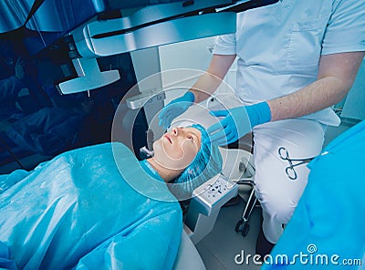 Laser vision correction. A patient and team of surgeons in the operating room Stock Photo