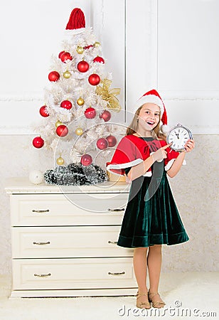 Last minute new years eve plan. Merry christmas concept. New year countdown. Girl kid santa hat costume hold clock Stock Photo