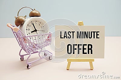 Last Minute Offer text message for promotion with alarm clock and shopping trolley cart on pink and blue background Stock Photo