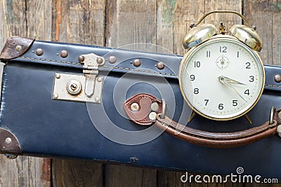 Last minute travel concept with old retro suitcase and alarm clock Stock Photo