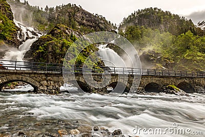 Latefoss twin waterfalls streams under the stone bridge archs, Odda, Hordaland county, Norway Stock Photo
