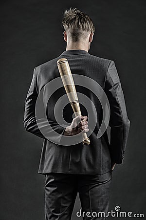 Latent aggression. Man with bat hides his aggression slow down and keep calm, rear view. Businessman or man in formal Stock Photo