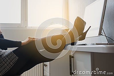 view of a hot brunete in office outfit sitting on the floor and working on computer Stock Photo