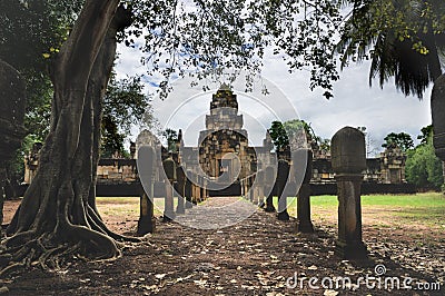 Laterite stone paved walkway with free-standing stone posts to the courtyard gates of ancient Khmer temple built of red sandstone Stock Photo