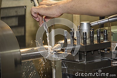 The lathe machine operator setup the cooling pipe for turning process Stock Photo