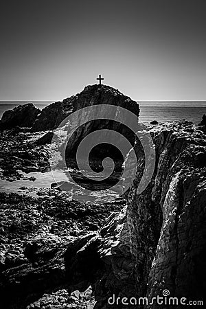 Latin cross or crux immissa or christian cross on the top of a rock, in the midd Stock Photo