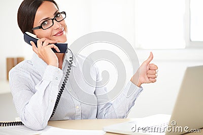 Latin employee happily doing customer service Stock Photo