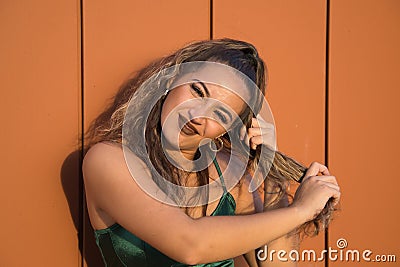 Latin and Hispanic girl, young and beautiful, with green eyes and big eyelashes, pulling her hair in a funny attitude. Concept Stock Photo