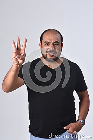 Latin man with finger in the shape of number 3 Stock Photo