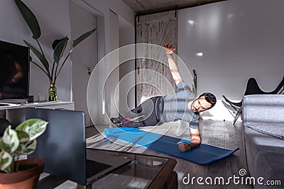 Latin man at home for pushup or plank training online Stock Photo