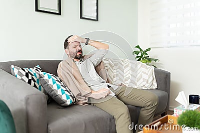 Feverish guy feeling unwell at home Stock Photo