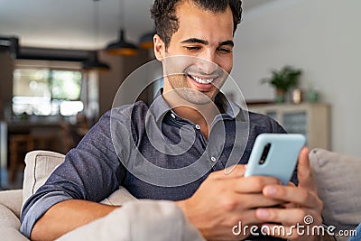 Latin man using smartphone at home Stock Photo