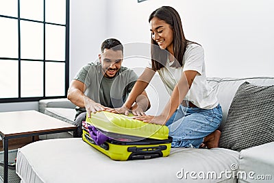 Latin man and woman couple smiling confident close travel suitcase at home Stock Photo