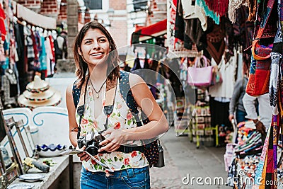 Latin woman backpacker shopping in a Tourist Market in Mexico City, Mexican Traveler in America Stock Photo