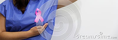 Latin woman disposable blue surgical gown and pink ribbon for campaign against breast cancer Stock Photo