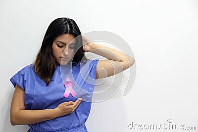 Latin woman disposable blue surgical gown and pink ribbon for campaign against breast cancer Stock Photo