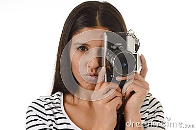 Latin woman taking pictures looking through the viewfinder of an old cool retro vintage photo camera Stock Photo