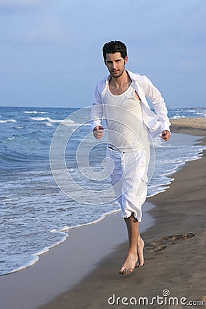 Latin young man white shirt walking blue beach Stock Photo