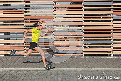 A Latina woman sprints in a race. Runner Stock Photo