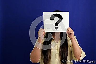 Latino adult woman shows a question mark, wonders, doubts, suspects, assumes, fears and distrusts Stock Photo