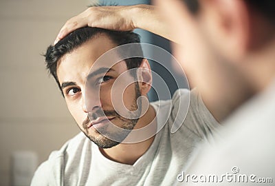 Man worried for alopecia checking hair for loss Stock Photo