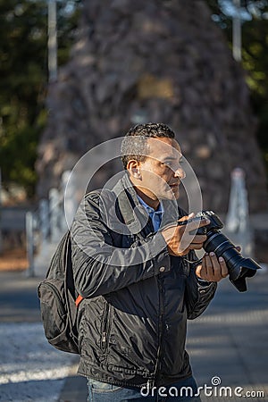 Latino photojournalist working on the street Stock Photo
