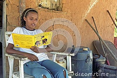 Latino teenager girl is reading a storybook Editorial Stock Photo