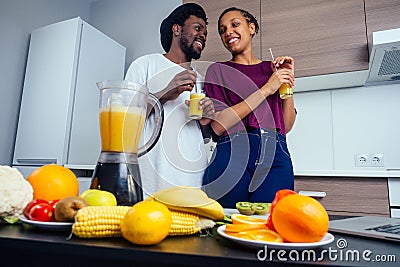 Latino woman and man working at juice bar and cutting fruits, making fresh smoothies from bananas,orange and melon. she Stock Photo