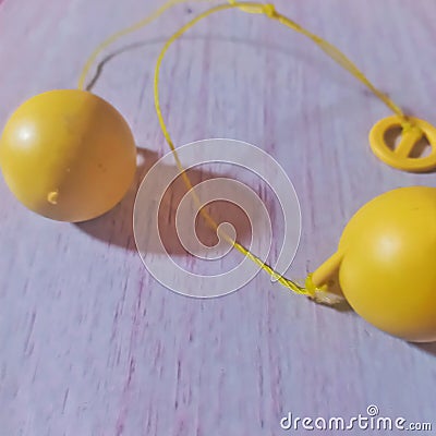 Lato-lato is a traditional toy consisting of a pair of plastic or rubber balls attached to a string to form a pendulum. Stock Photo