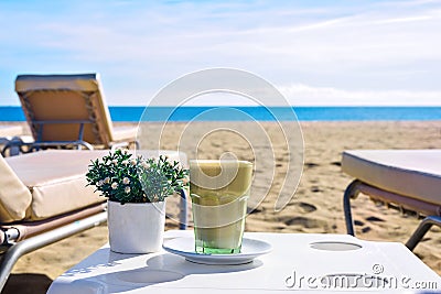 Latte at the beach. Iced Coffee Frappuccino or frappe in a tall glass. Sea view background Barcelona Spain Stock Photo