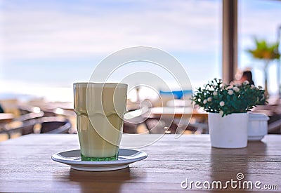 Latte at the beach. Iced Coffee Frappuccino or frappe in a tall glass. Sea view background Barcelona Spain Stock Photo