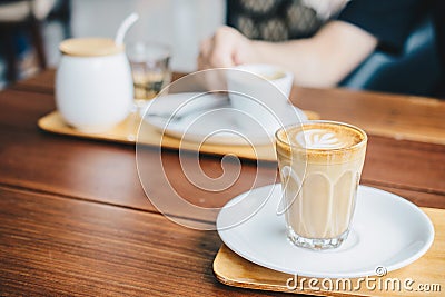 A glass cup of Piccolo latte on wooden table in the coffee shop. Stock Photo