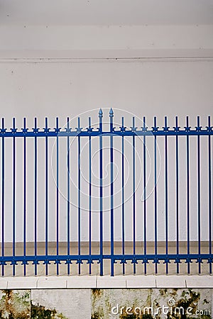 Lattice gate in the courtyard of the house against the background of a white wall Stock Photo