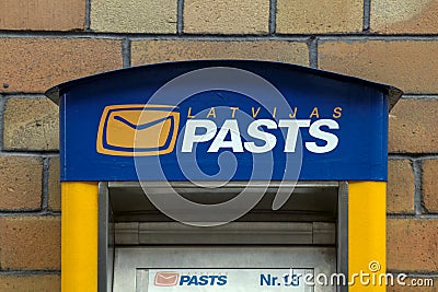 Latvijas pasts or in English Latvian Post mail box on brick wall background Editorial Stock Photo