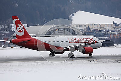Lauda Airline plane taxiing on a snowy runway, Innsbruck Airport INN Editorial Stock Photo