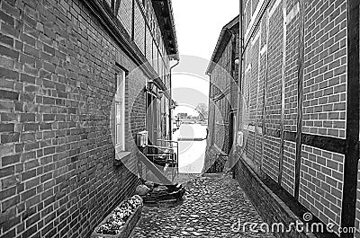 Black and white photo from a historical cobblestone alley with half-timbered houses to the Elbe river Editorial Stock Photo