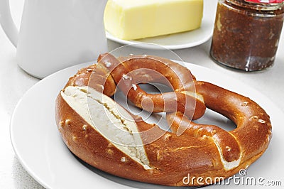 A laugenbrezel, a german pretzel, on a set table for breakfast Stock Photo
