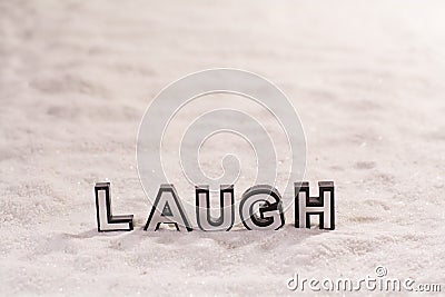 Laugh word on white sand Stock Photo