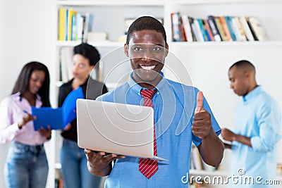 Laughing african american businessman at computer with group of black business people Stock Photo