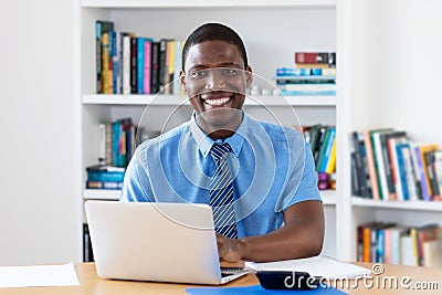 Laughing african american businessman with necktie at computer Stock Photo