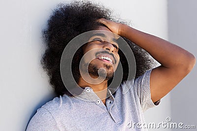 Laughing afro man with hand in hair looking away Stock Photo