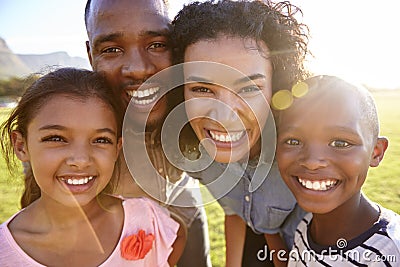 Laughing black family outdoors, close up, back lit portrait Stock Photo